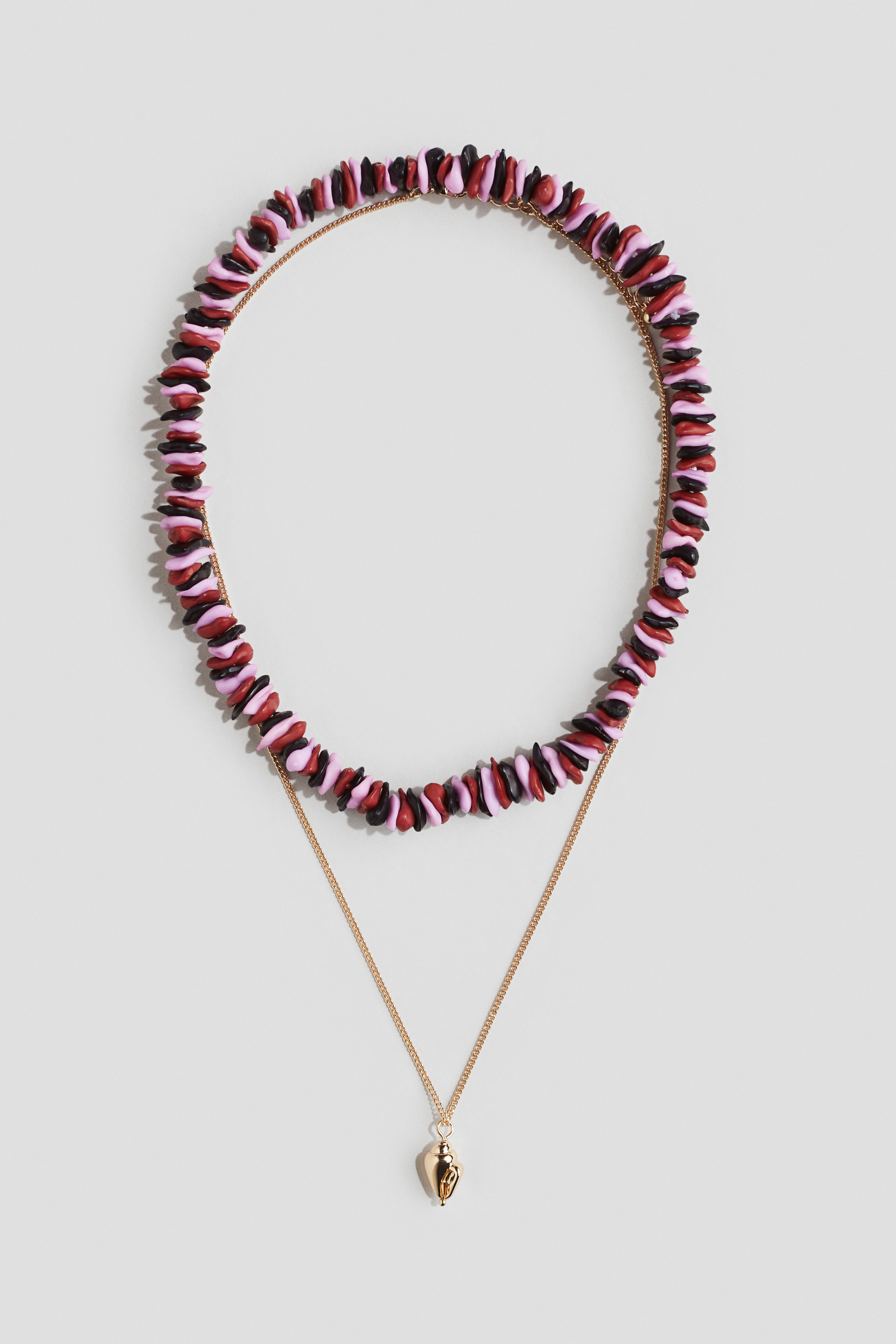 서로 다른 디자인의 목걸이 세트. 플라스틱 비즈로 마감된 신축성 목걸이 1피스, 소라 껍데기 모양의 펜던트 장식이 있는 금속 체인 목걸이 1피스 구성. 체인 목걸이는 트리거 후크로 여밈. 이미지