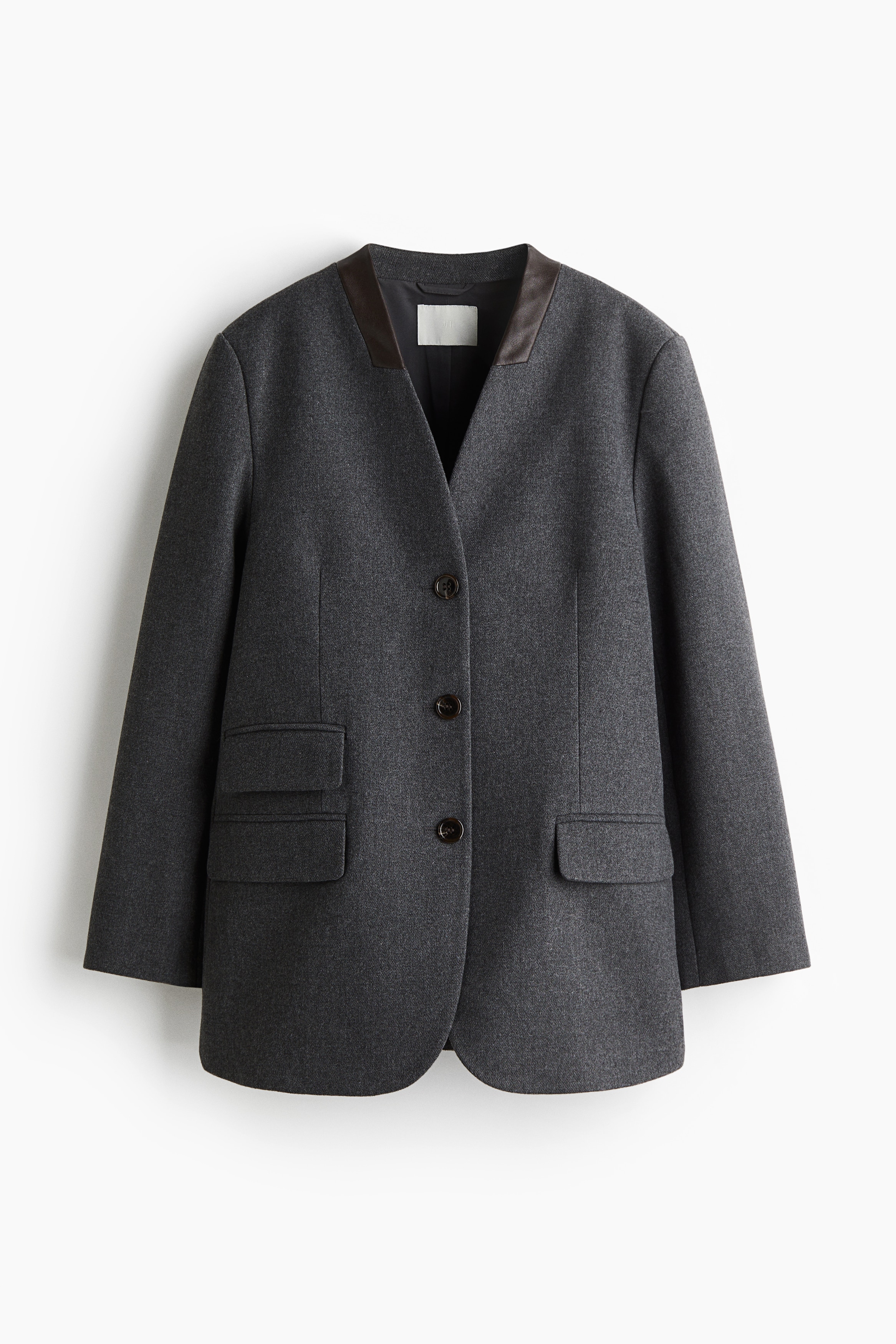 Long, collarless blazer in a felted weave with a coated detail around the neckline. Single-breasted front, jetted front pockets with a flap, shoulder pads and kissing buttons at the cuffs. Pleats at the back of the hem. Lined. 이미지