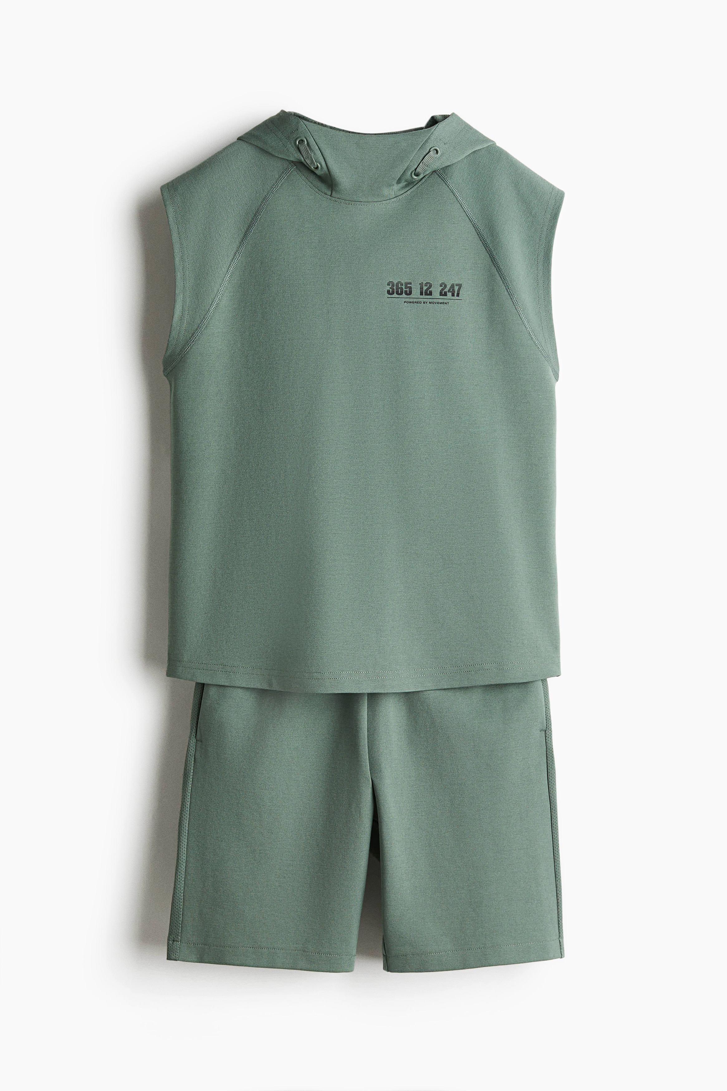 부드러운 저지 소재의 스포츠 상하의 세트. 상의 - 래글런 스타일의 캡소매 후디. 드로스트링 장식이 있는 후드에 메쉬 안감이 부착됨. 세미 라운드 헴라인. 하의 - 드로스트링이 있는 신축성 허릿단의 반바지. 옆면 히든 포켓. 양쪽 옆면 통기성 메쉬 디테일. 이미지