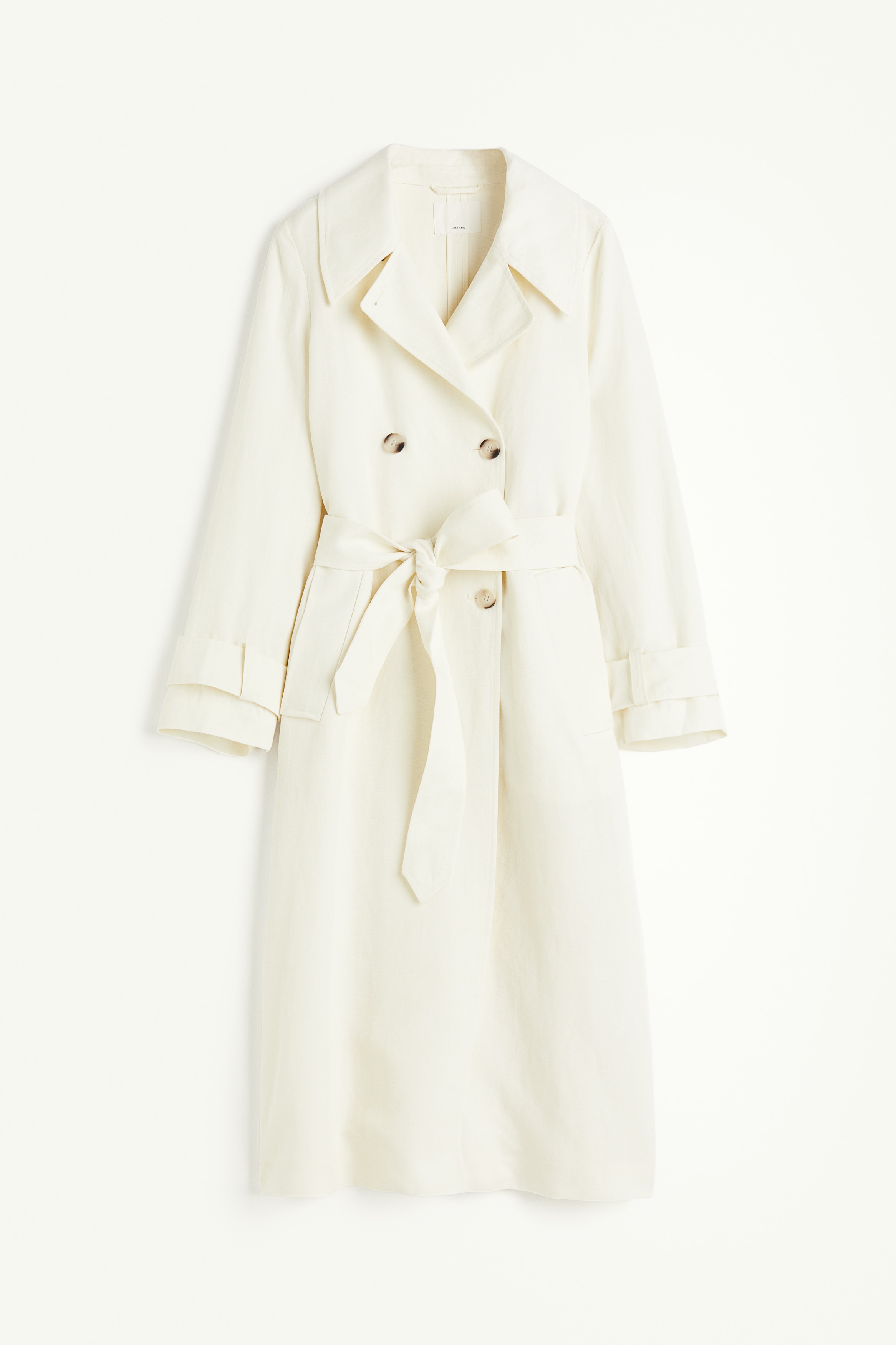 리넨과 리오셀이 혼방된 더블 브레스티드 트렌치코트. 맥시 기장. 노치트 라펠. 앞면 버튼. 와이드한 탈부착식 끈 벨트를 두른 디자인. 옆면 웰트포켓. 긴소매. 탭과 버튼이 있는 소맷단. 뒷면 스톰 플랩. 뒷트임. 안감 생략. 이미지