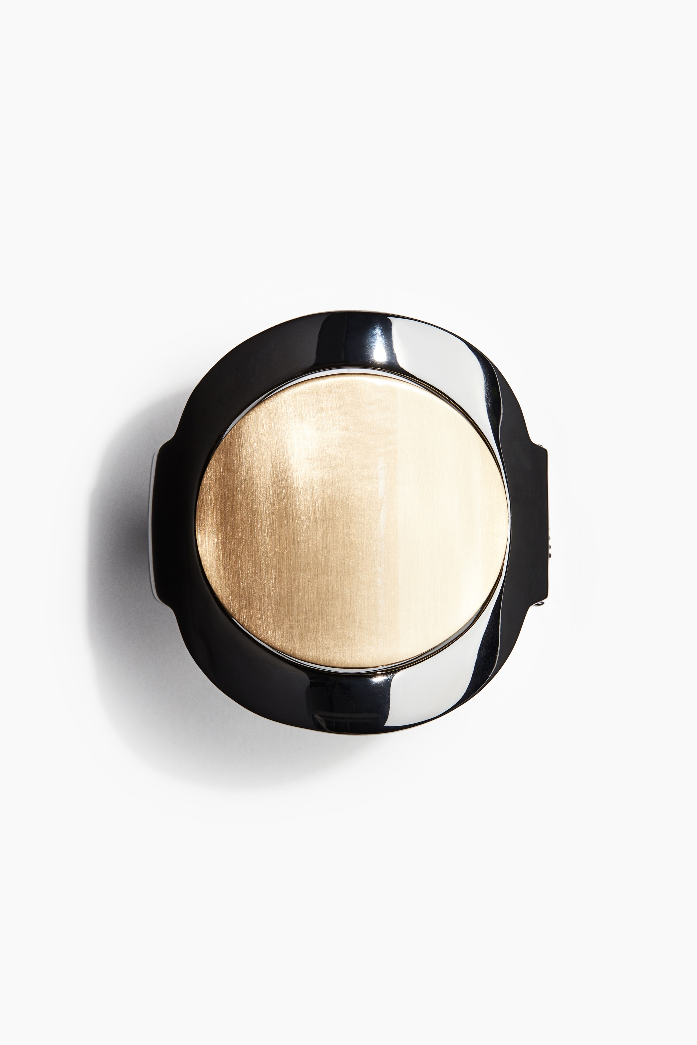 반짝이는 금속 소재의 힌지 커프 팔찌. 앞면이 포인트 컬러의 둥글납작한 브러시트 금속 피스로 장식됨. 앞면 폭 7cm. 이미지