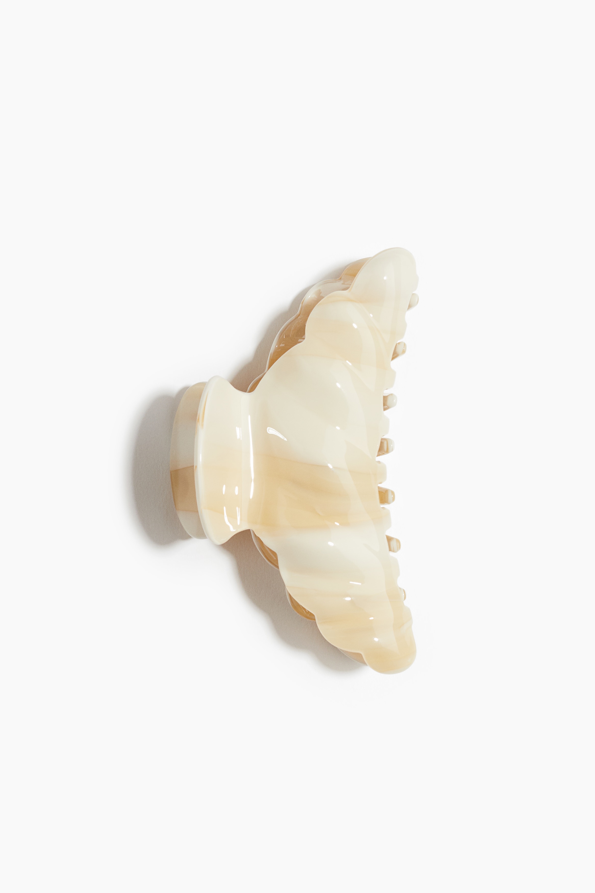 광택성 플라스틱 소재의 헤어 클로. 모서리가 스캘럽트 라인으로 마감됨. 이미지