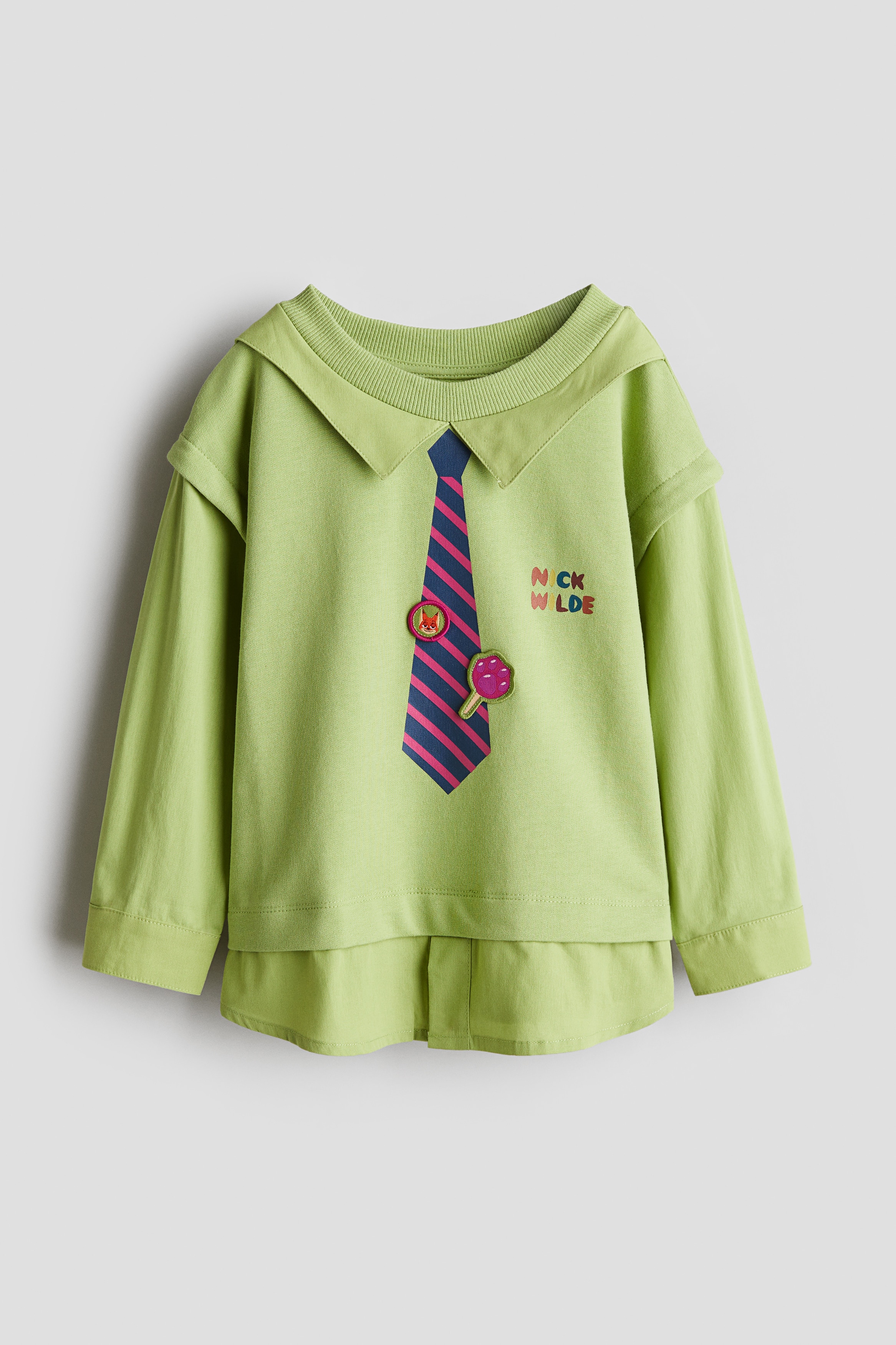 프린트가 있는 가벼운 스웨트셔츠 소재의 탑. 칼라와 소매, 아랫단이 부드러운 우븐 소재로 레이어링된 디자인. 라운드넥. 드롭 숄더. 소맷단 버튼. 이미지