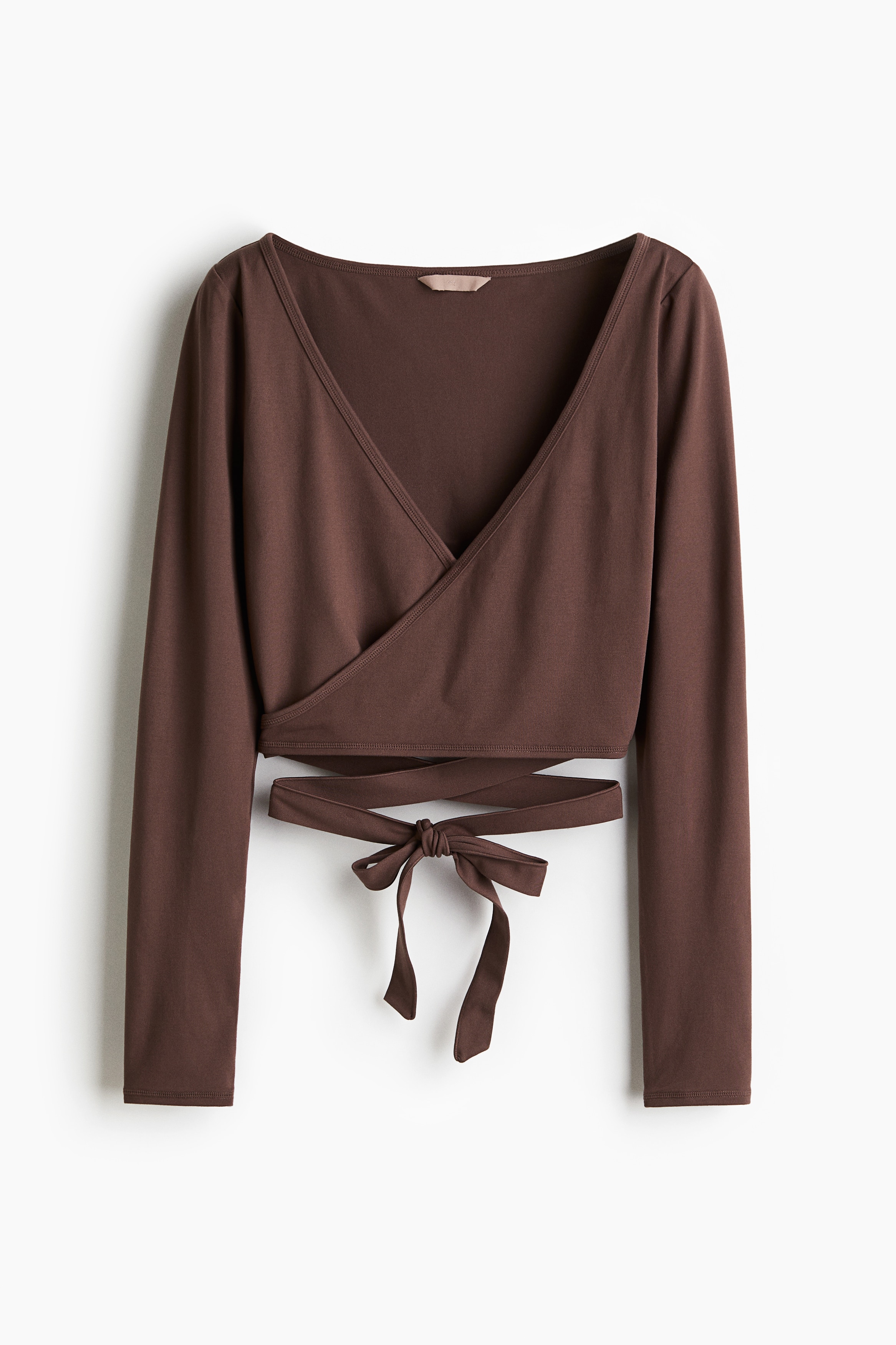 기모처리된 부드러운 저지 소재의 피트되는 크롭트 탑. 긴소매. 깊게 파인 V넥. 앞면이 랩스타일로 마감되었으며, 긴 끈을 허리에 둘러 묶는 디자인. 이미지
