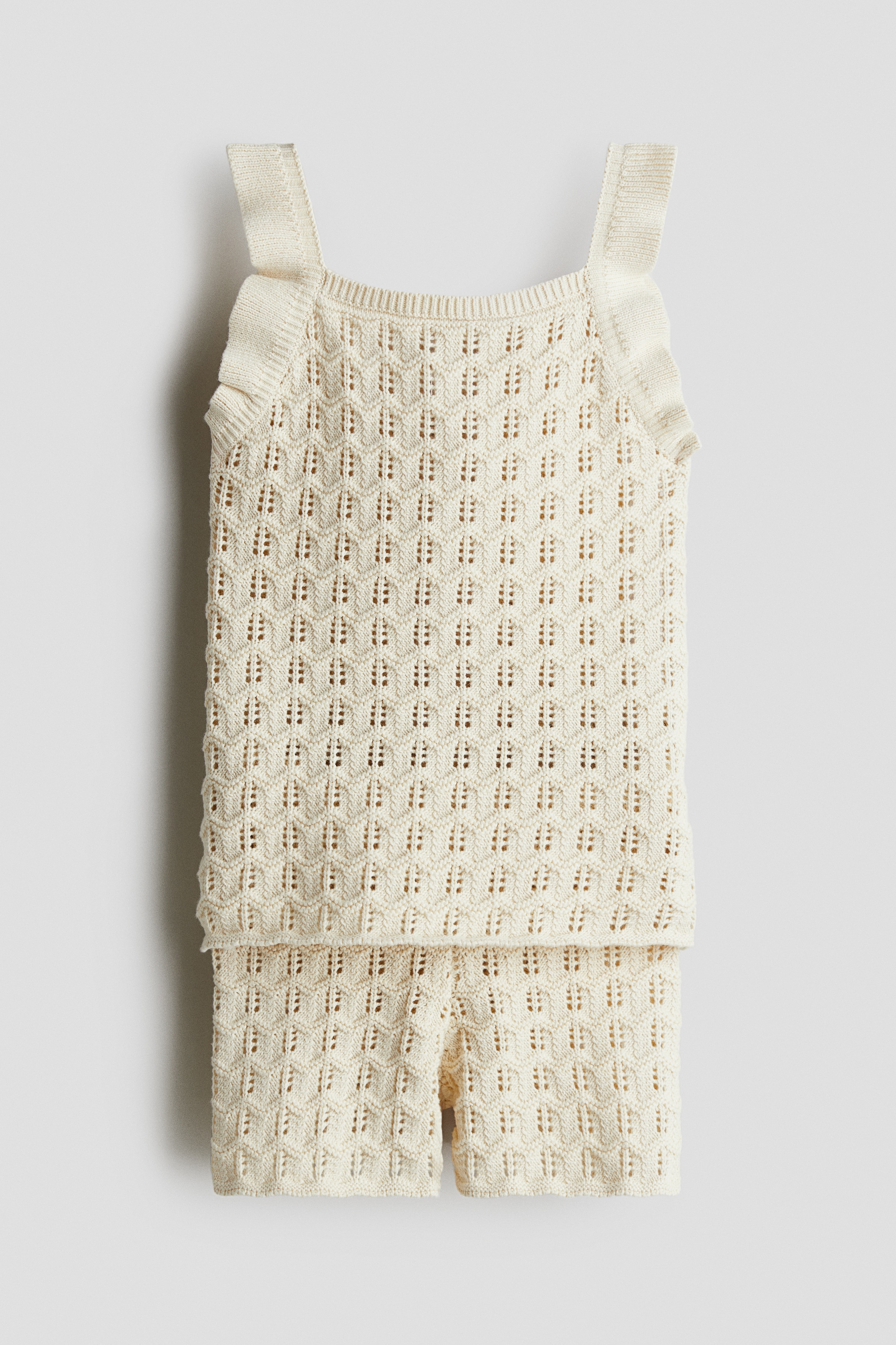 H & M Adorables. 고급 코튼을 사용한 포인텔 파인니트 소재의 스트랩 탑과 반바지 세트. 스캘럽트 라인의 트리밍 디테일. 탑 - 스퀘어넥. 반바지 - 밴딩으로 허리 사이즈 조절. H & M Adorables 컬렉션은 시대를 초월한 매력을 지닌 매우 편안하고 고급스러운 제품들로 엄선된 컬렉션입니다. 이미지