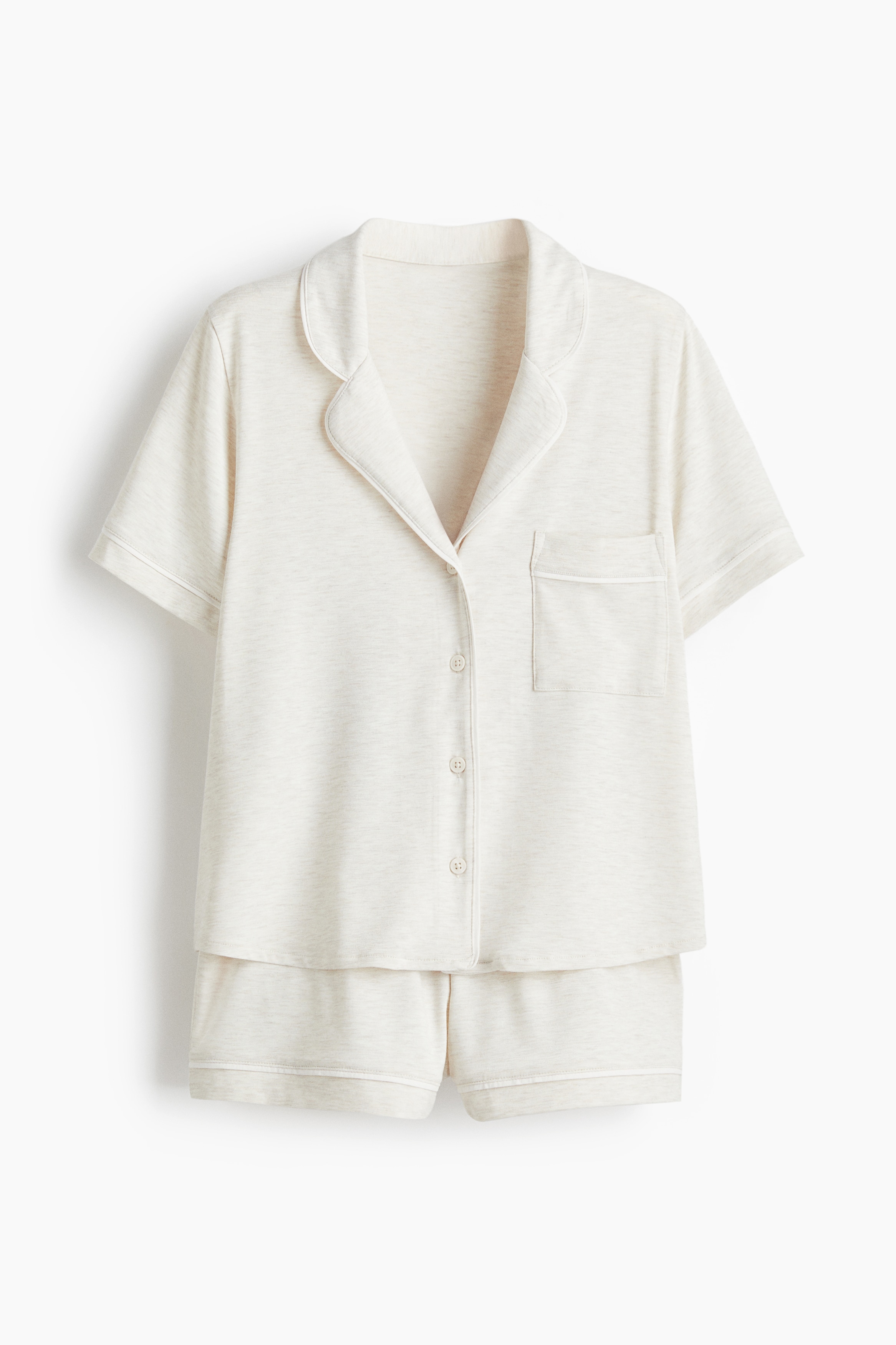 부드러운 저지 소재의 파자마 상하 세트. 대조적으로 배색된 파이핑 디테일. 상의 - 버튼업 스타일의 반소매 셔츠. 캠프 칼라. 세미 드롭 숄더. 가슴 포켓. 하의 - 허릿단에 밴딩이 내장된 반바지. 이미지