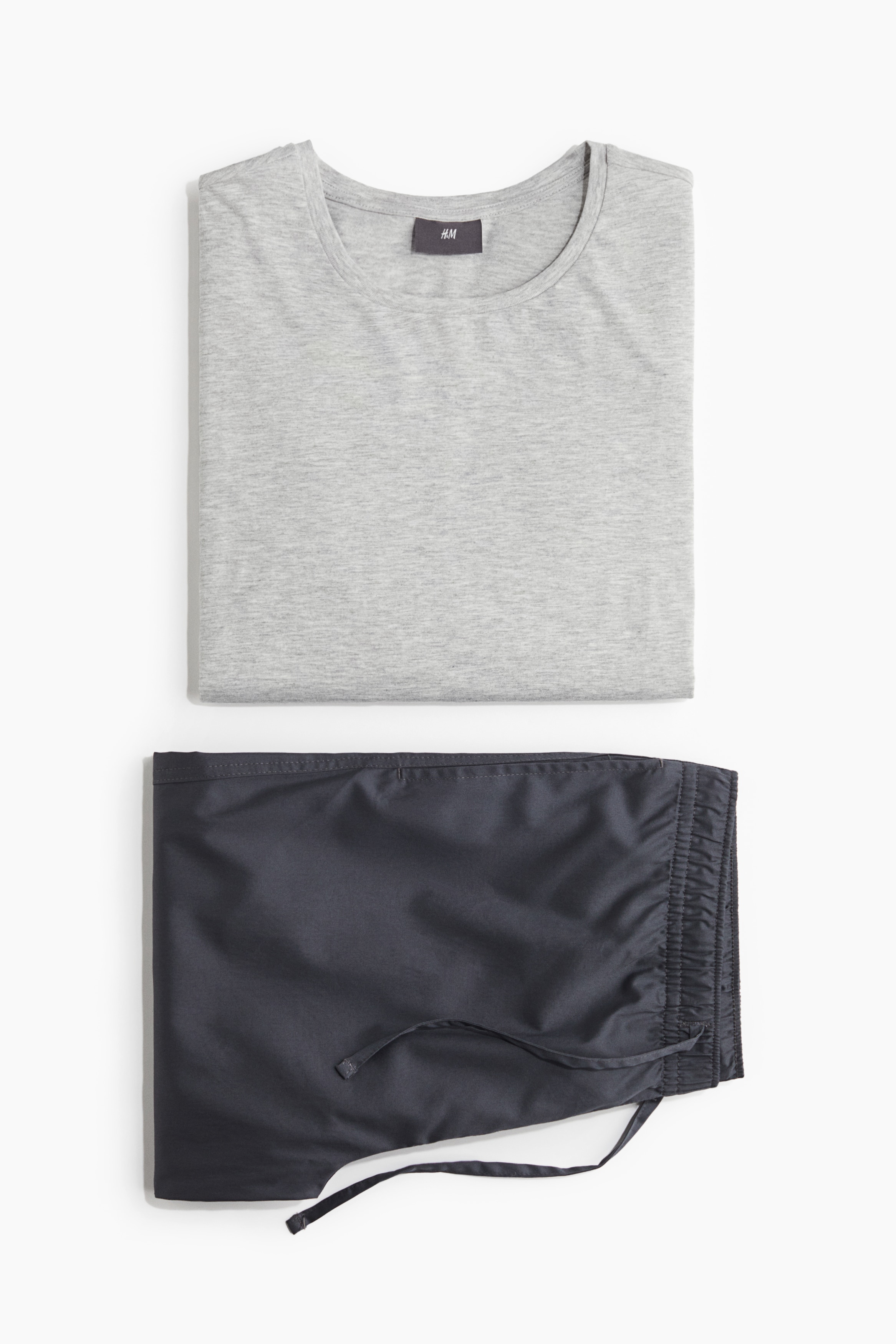 저지 탑과 새틴 팬츠로 구성된 파자마 상하 세트. 탑 - 긴소매, 라운드넥. 양쪽 옆면에 트임이 있는 스트레이트 헴라인. 팬츠 - 드로스트링이 있는 신축성 허릿단. 페이크 플라이. 옆면 포켓. 이미지