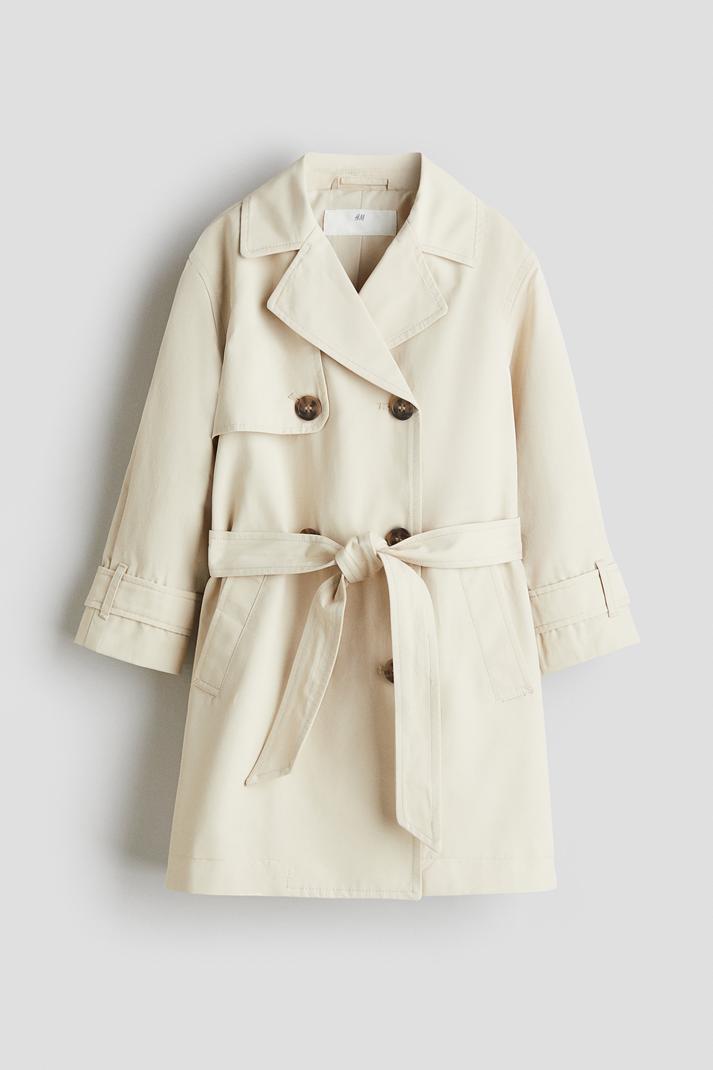 코튼이 혼방된 더블 브레스티드 트렌치코트. 노치트 라펠. 스톰 플랩. 앞면 버튼. 탭과 버튼이 있는 소맷단. 탈부착식 벨트를 두른 디자인. 옆면 웰트포켓. 뒷트임. 안감 부착. 이미지