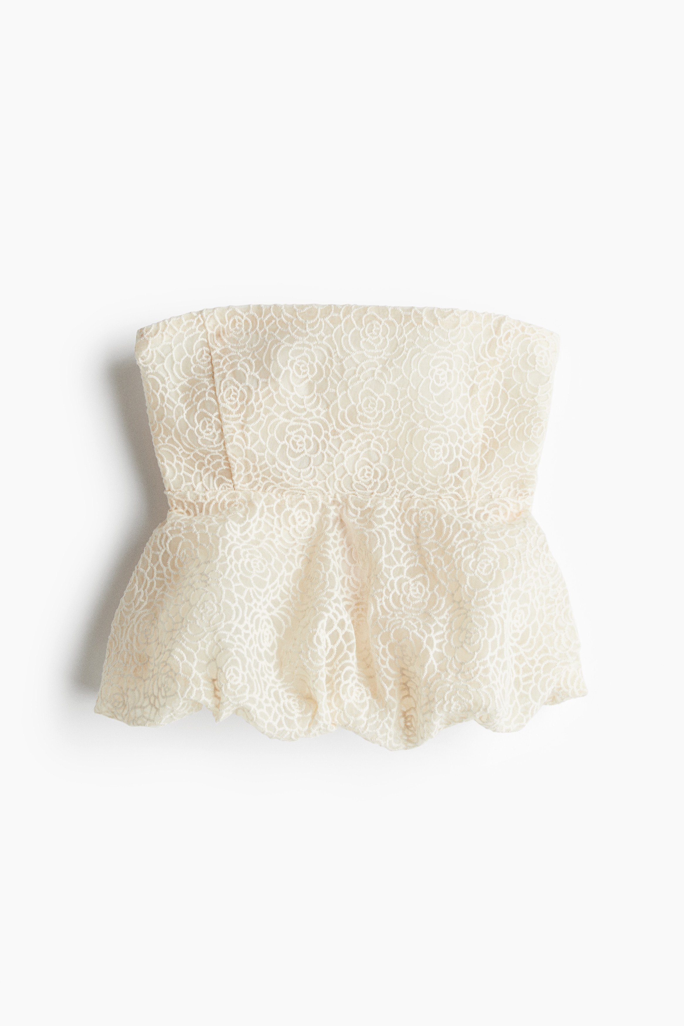 자수 패턴이 있는 시스루 소재의 피트되는 스트랩리스 탑. 흘러내림 방지용 상단 실리콘 내장. 한쪽 옆면 히든 지퍼와 후크 클로저. 버블 헴라인이 연출하는 퍼프 실루엣. 안감 부착. 이미지