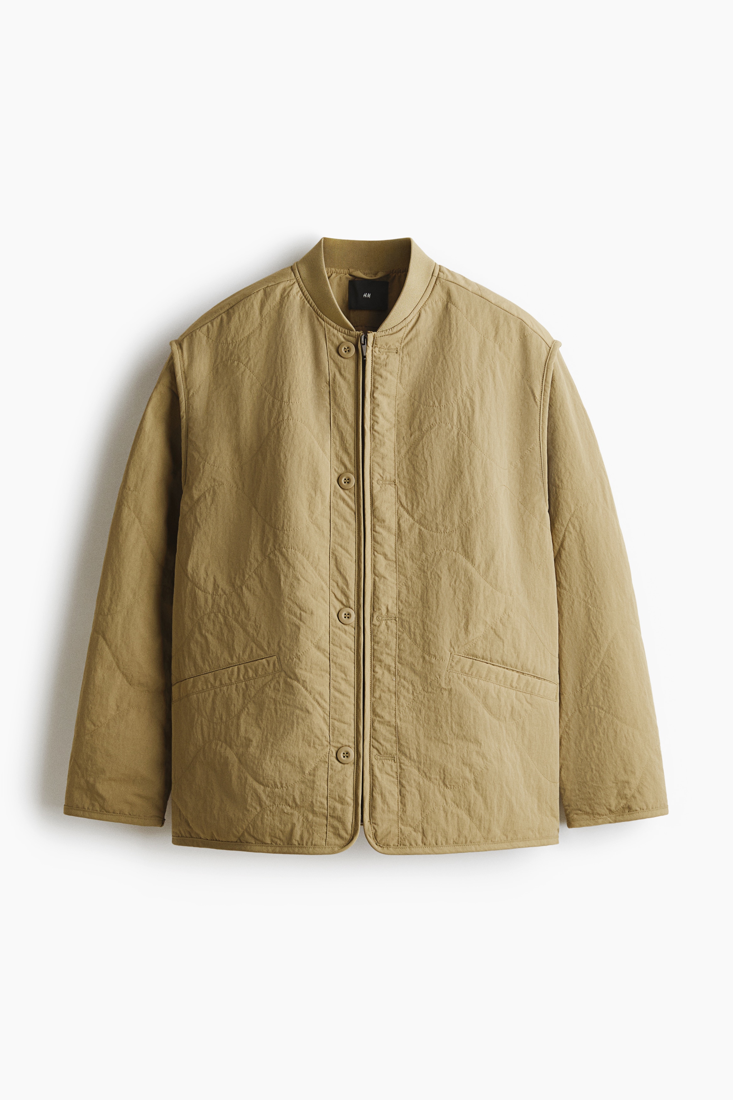 퀼팅처리된 나일론 소재의 얇은 패딩 재킷. 리브드 마감된 하프넥. 히든 지퍼 클로징. 앞면 버튼 장식. 세미 드롭 숄더. 앞면 웰트포켓. 안감 부착. 이미지