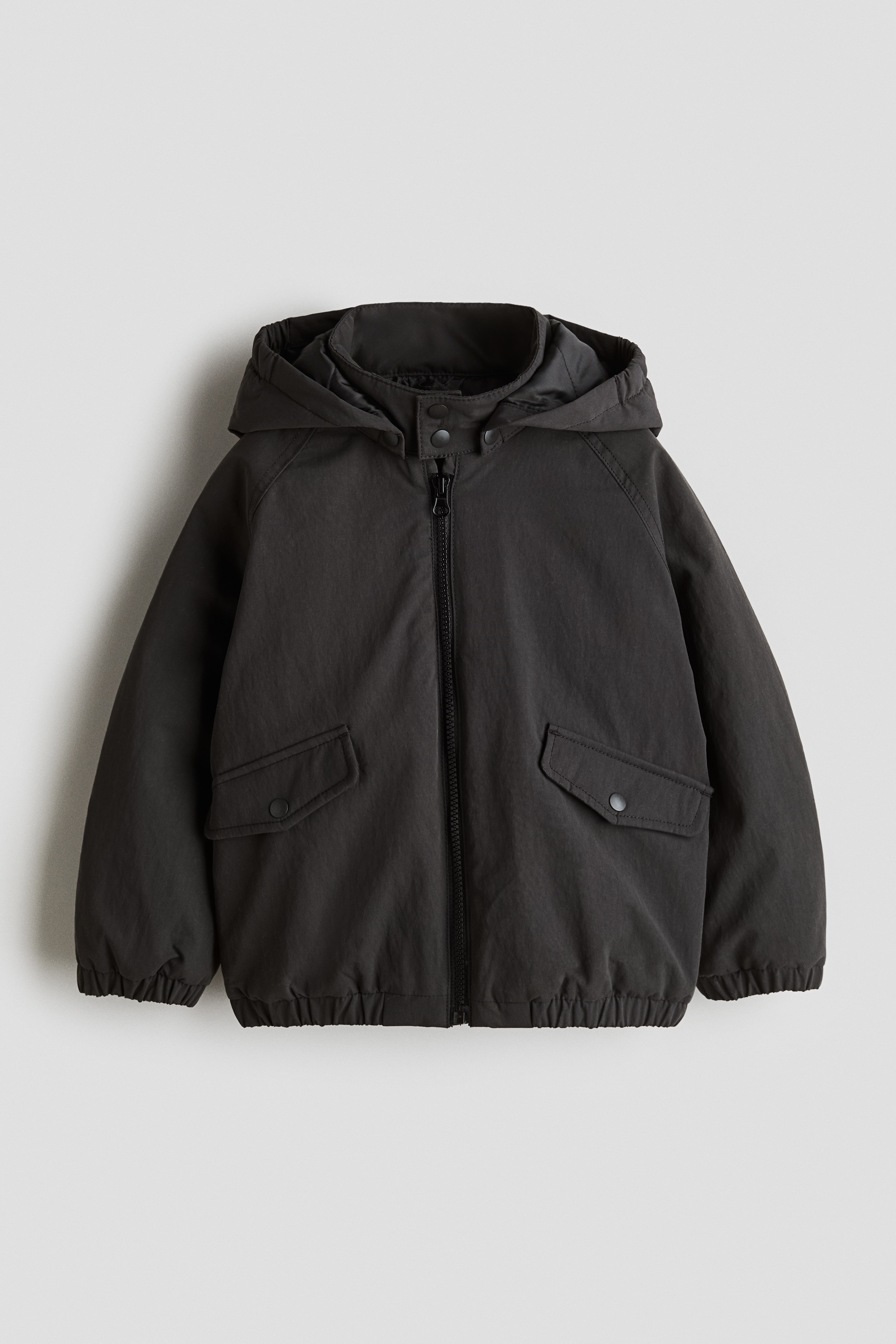 발수성 나일론 소재의 재킷. 스냅버튼으로 여미는 스탠드 칼라. 집업 스타일. 스냅버튼으로 여닫는 앞면 플랩포켓. 래글런 소매. 신축성 소맷단과 아랫단. 안감 부착. 불소 화합물을 첨가하지 않은 BIONIC-FINISH® ECO 발수 코팅 소재. 이미지