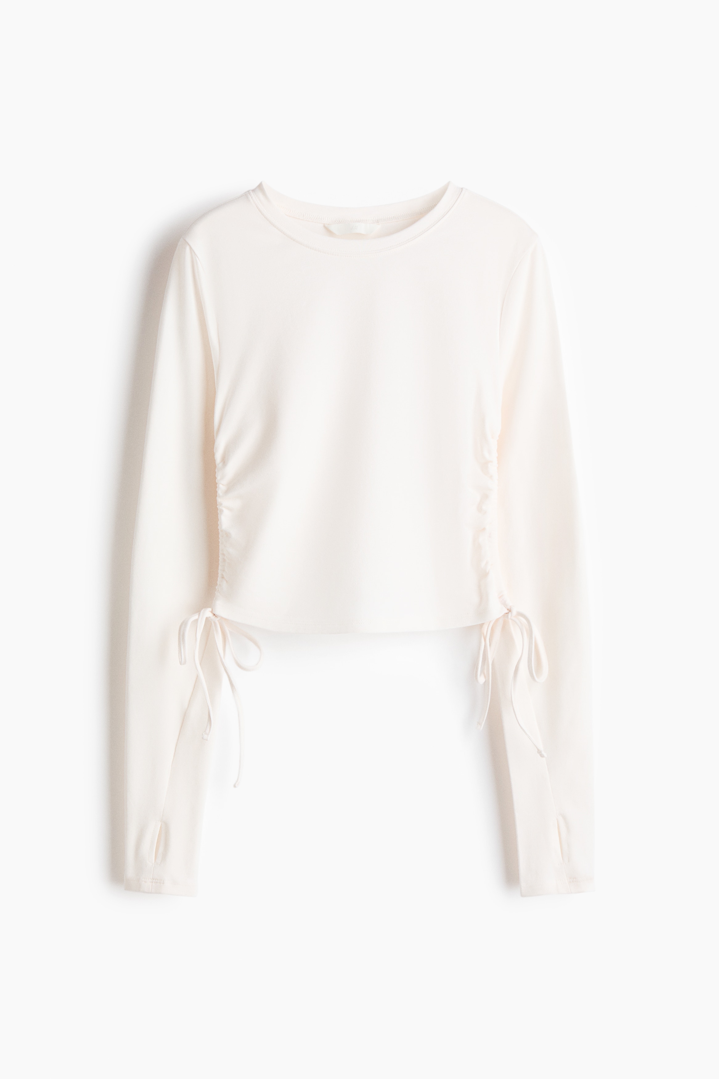 부드러운 코튼 저지 소재의 긴소매 라운드넥 탑. 엄지손가락 구멍이 있는 소맷단. 양쪽 옆면의 가는 드로스트링으로 가볍게 드레이핑 효과를 준 디자인. 이미지