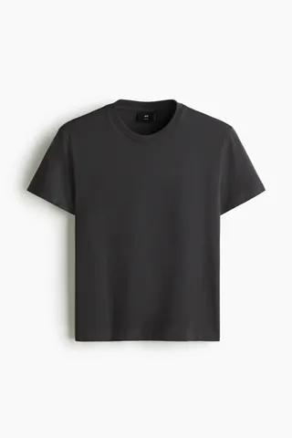 코튼 저지 소재의 크롭트 티셔츠. 리브드 마감된 라운드넥. 스트레이트 헴라인. 바디 라인을 감싸며 피트되는 슬림핏 실루엣. 이미지