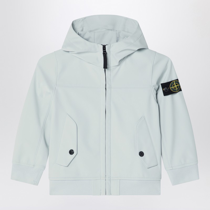 밝은 파란색의 스톤 아일랜드 후드 재킷으로, 앞면 지퍼 여밈, 컴퍼스 로고 라벨이 부착된 긴 소매, 골지 마감, 그리고 플랩과 버튼이 달린 앞주머니 두 개가 특징입니다. 이미지
