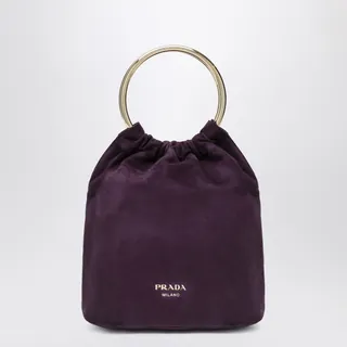 원형 메탈 핸들, 탈착 가능한 숄더 스트랩, 골드 톤 하드웨어, 그리고 앞면에 양각 로고 레터링이 특징인 프라다 플럼 스웨이드 미니 버킷백입니다. 이미지
