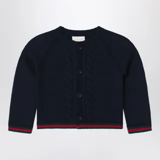 구찌 크루넥 블루 울 가디건은 긴 소매, 전면 버튼 여밈, 그린-레드-그린 웹 리본이 특징인 골지 가장자리, 그리고 전면의 케이블 패턴 디테일이 돋보입니다. 이미지
