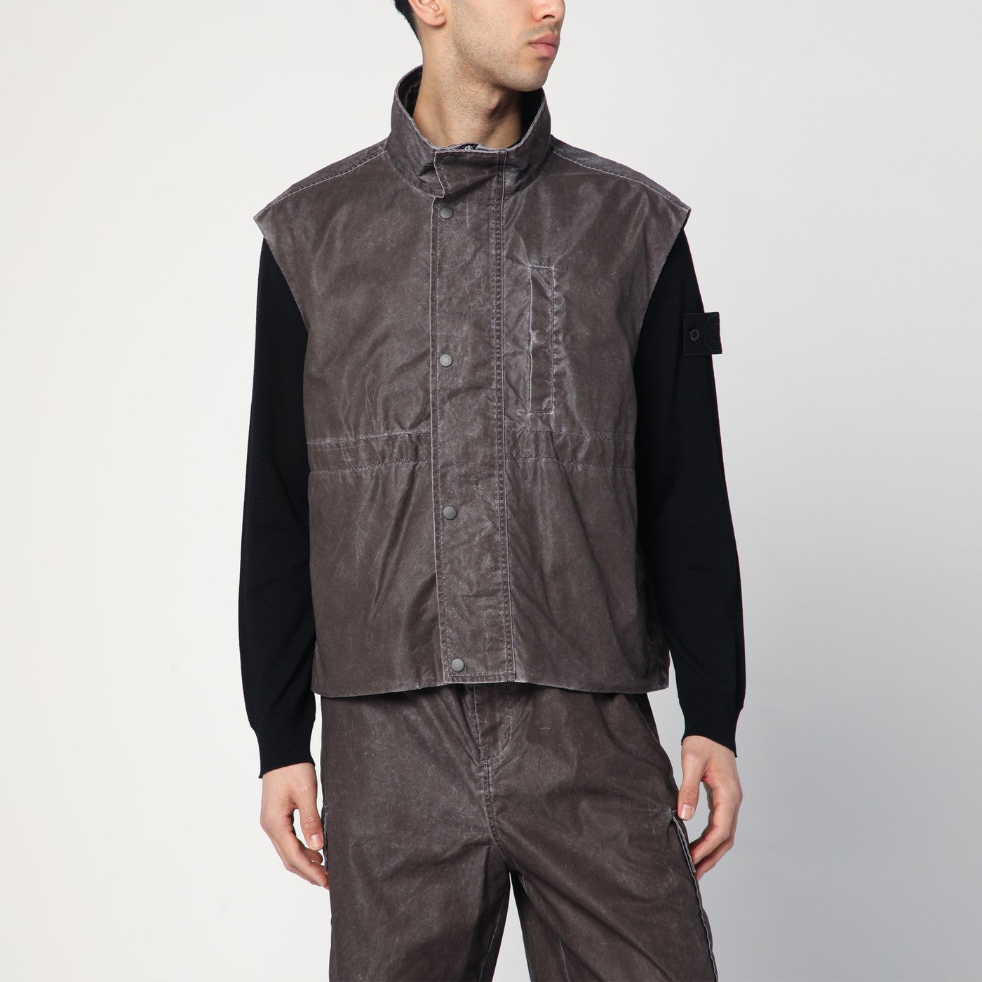 아워레가시의 브라운 빈티지 이펙트 나일론 질레는 앞면 지퍼와 스냅 버튼 클로저, 두 개의 측면 웰트 포켓, 허리 조임끈, 가슴 부분의 웰트 포켓, 그리고 하이넥 칼라가 특징입니다. 이미지