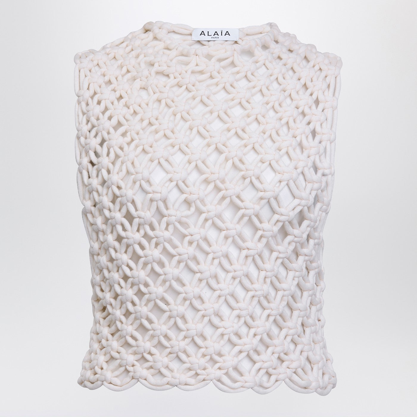 알라이아의 화이트 민소매 크루넥 탱크톱은 면 혼방 소재로 손으로 엮은 듯한 매듭 디자인과 박시한 컷이 특징입니다. 이미지