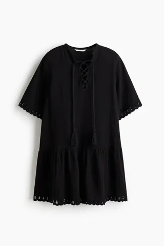 부드러운 코튼 모슬린 소재의 루즈핏 미니 드레스. 소맷단과 아랫단에 펀칭 자수 장식이 있음. 밴드 칼라. 태슬이 달린 끈을 사용한 레이스업 스타일의 V넥. 반소매. 하단 솔기에 주름을 잡아 풍성함을 더한 디자인. 안감 생략. 이미지