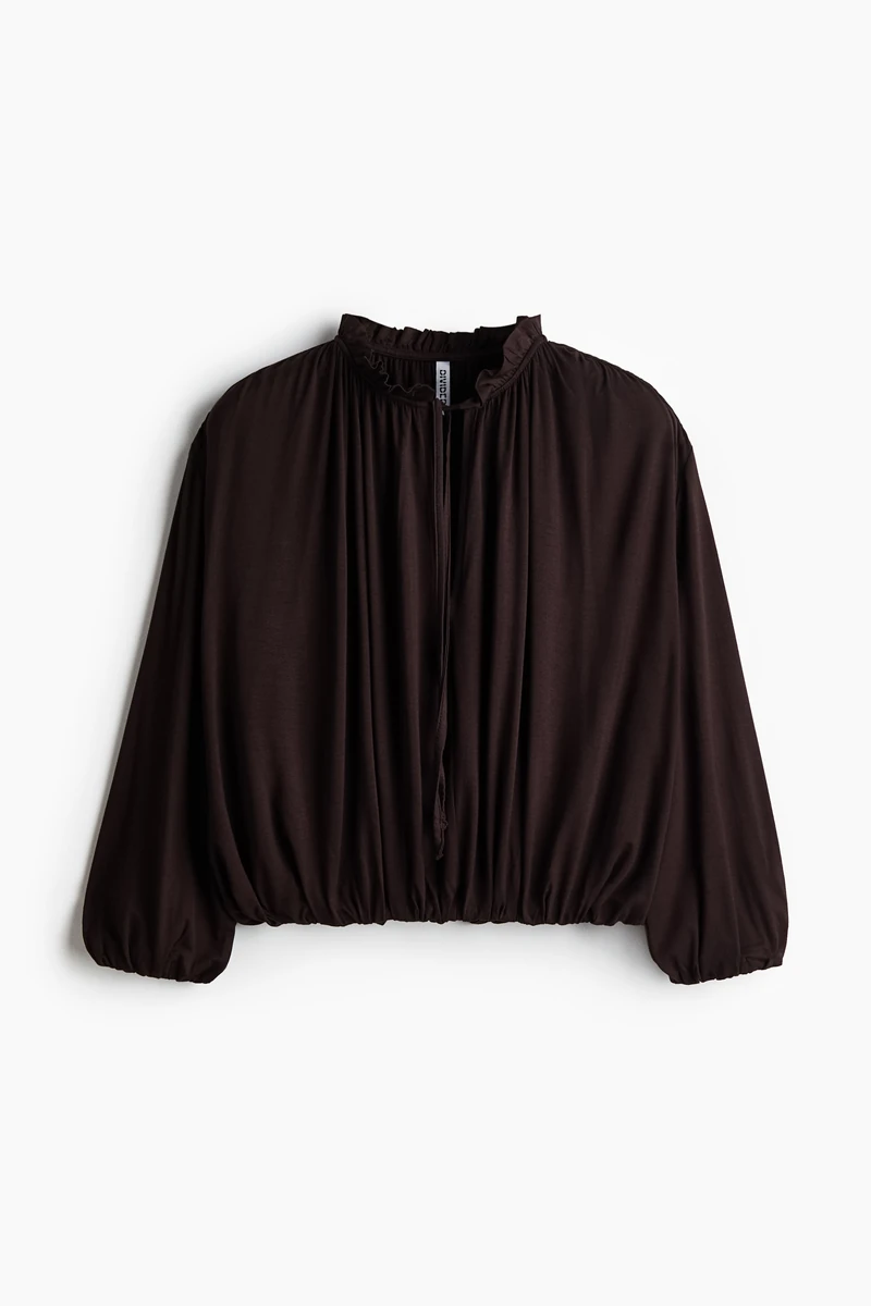 Short, oversized top in stretch viscose jersey with gathered seams throughout the design creating a draped effect. Features a frill collar, an opening with narrow ties at the front and 3/4-length sleeves. Concealed elastication at the cuffs and hem. 이미지1