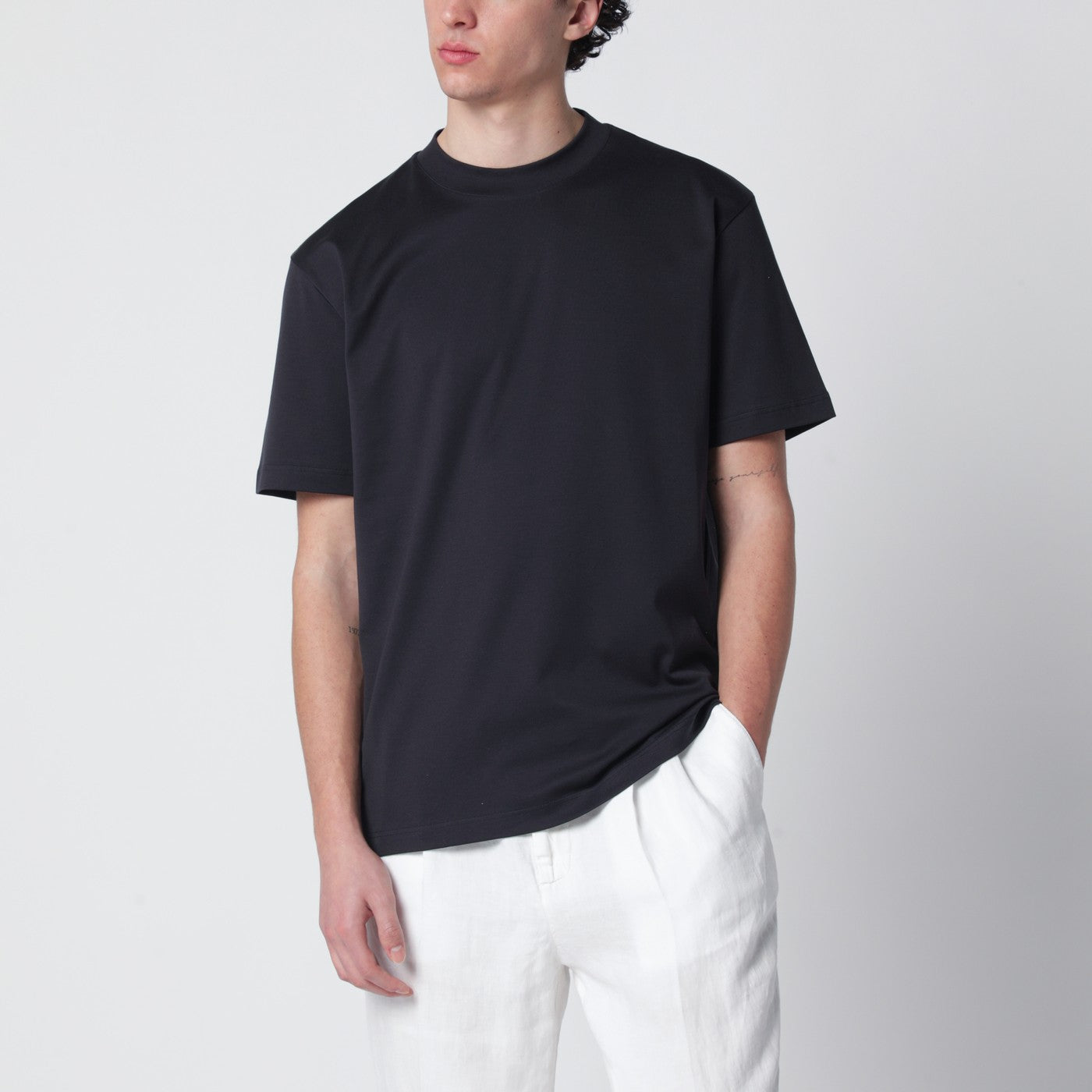 블루 코튼 소재의 로로피아나 크루넥 티셔츠. 짧은 소매와 골지 크루넥이 특징이며, 뒷면에는 톤온톤으로 수놓아진 로고 레터링이 섬세함을 더합니다. 이미지