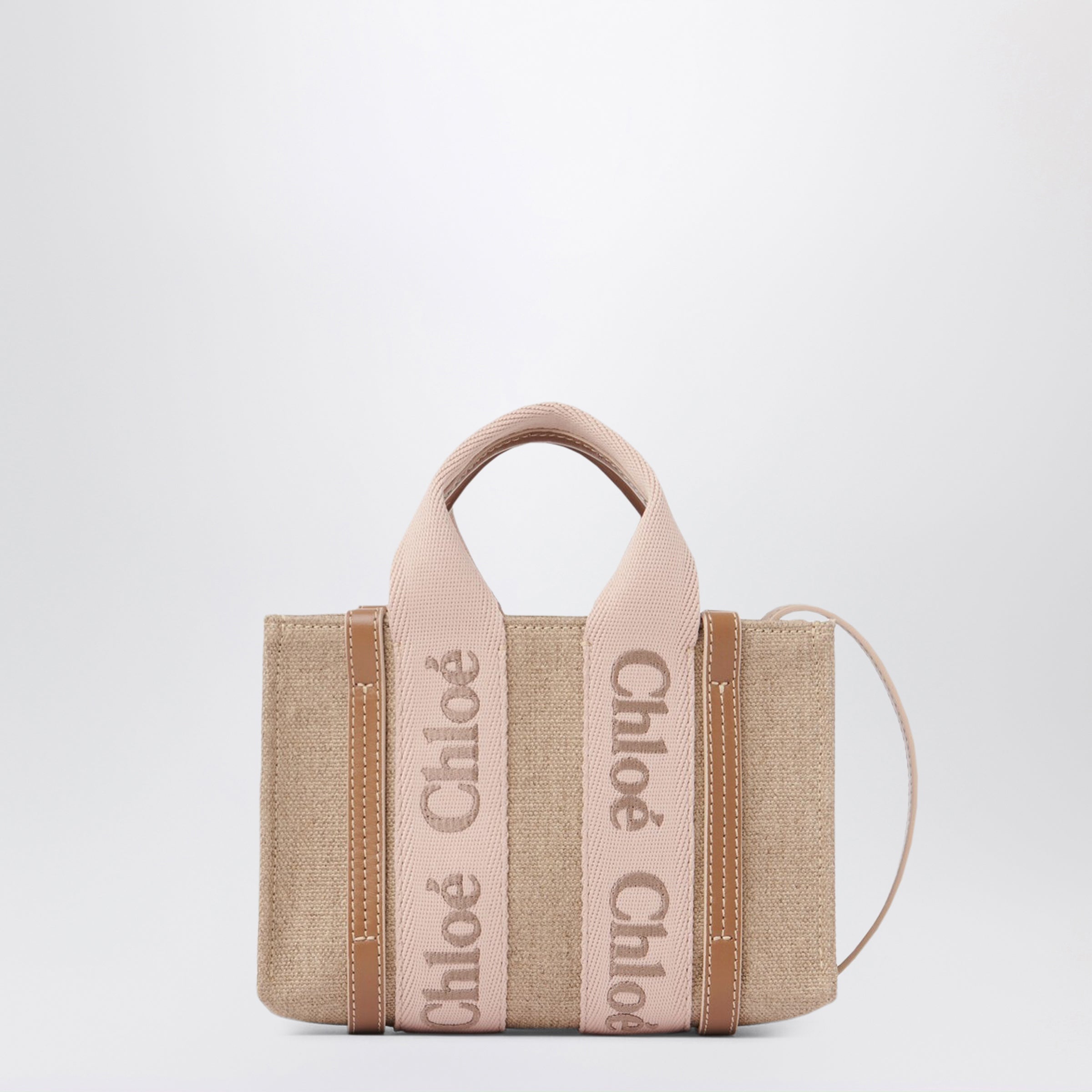 린넨 캔버스와 송아지 가죽으로 제작된 클로에의 스몰 토트백. 블러쉬 베이지 색상이며, 자수 클로에 로고가 새겨진 웨빙, 두 개의 짧은 핸들, 탈부착 및 조절 가능한 긴 숄더 스트랩이 특징입니다. 넓은 메인 수납공간과 내부 플랫 포켓이 있습니다. 이미지