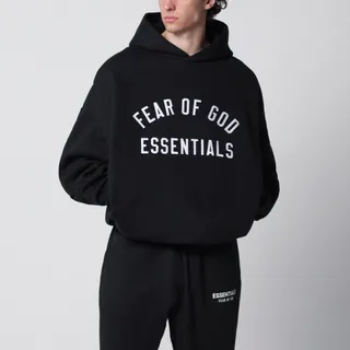 Fear of God Essentials의 코튼 혼방 플리스 후드티. 빈티지 블랙 색상이며, 옆 솔기 포켓과 드롭 숄더의 긴 소매가 특징입니다. 전면에는 대비되는 색상의 로고 자수가 새겨져 있습니다. 이미지