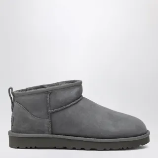 UGG 클래식 마이크로 스웨이드 부츠입니다. 라이트 브론즈 컬러의 로우 프로파일 디자인으로, 후면 풀 탭이 있어 착용이 간편합니다. 양털 안감과 인솔을 사용하여 따뜻하며, 가벼운 사탕수수 EVA 아웃솔과 재활용 폴리에스터 바인딩으로 제작되었습니다. 인솔과 힐 부분에 UGG 로고가 각인되어 있습니다. 이미지