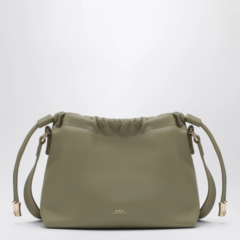 A.P.C.의 니논 미니 백으로, 리사이클 레더 효과 소재로 제작되었습니다. 컬러는 클레이 그린이며, 상단 드로우스트링과 내부 자석 잠금 장치가 특징입니다. 숄더 및 크로스바디 스트랩이 포함되어 있으며, 내부에 포켓이 하나 있습니다. 전면에는 'A.P.C. Rue Madame Paris' 로고가 각인되어 있습니다. 이미지1