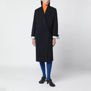 로에베의 울 코트입니다. 다크 네이비 컬러로 제작되었으며, 트롱프뢰유 스트라이프 커프스 디테일이 돋보입니다. 여유로운 핏의 미디 기장으로 테일러드 실루엣을 자랑하며, 노치 라펠과 전면 버튼 여밈, 체스트 웰트 포켓 및 플랩 포켓, 백 벤트가 특징입니다. 전체 안감이 처리되어 있으며 커프스 안쪽에는 더블 L 로고 자수가 새겨져 있습니다. 이미지