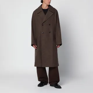 르메르의 펠트 울과 알파카 혼방 소재 더블 브레스티드 코트입니다. 머드 컬러의 롱 오버사이즈 핏으로 제작되었습니다. 안감이 없는 구조에 헤링본 테이프 디테일로 마감되었으며, 버튼홀과 언더칼라 버튼이 있는 테일러드 칼라가 특징입니다. 긴 래글런 소매와 더블 브레스티드 클로저, 사이드 래글런 포켓 및 내부 웰트 포켓을 갖추고 있습니다. 이미지