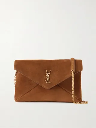 생 로랑의 '카산드라' 라인은 유명한 'YSL' 로고를 디자인한 그래픽 디자이너의 이름에서 유래했습니다. 이탈리아에서 부드러운 스웨이드 소재로 제작된 이 숄더백은 유행을 타지 않는 엔벨로프 형태와 탈부착 가능한 골드 톤 체인 스트랩이 특징입니다. 컴팩트한 내부 공간은 카드홀더, 립스틱, 휴대폰 등 필수품을 수납하기에 충분합니다. 이미지