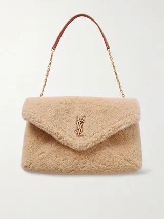 생 로랑의 '카산드라' 라인은 유명한 'YSL' 로고를 디자인한 그래픽 디자이너의 이름을 따서 명명되었습니다. 이탈리아에서 시어링 소재로 제작된 이 숄더백은 타임리스한 엔벨로프 형태를 갖추고 있으며, 완전히 탈부착 가능한 레더 트리밍 골드 톤 체인 스트랩이 특징입니다. 컴팩트한 내부 공간은 카드홀더, 립스틱, 휴대폰과 같은 필수품을 수납하기에 충분합니다. 이미지