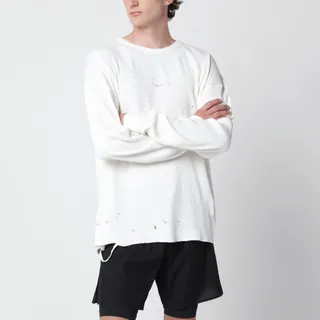새티스파이의 코튼 소재 티셔츠입니다. 에이지드 에크루 컬러로 구성되었으며, 긴팔 디자인과 리플렉티브 레터링 로고가 특징입니다. 외부 탈부착 가능한 케어 라벨, 크루넥, 레귤러 핏, 레이저 커팅 홀 디테일이 돋보입니다. 이미지