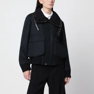 사카이의 울 소재 자켓입니다. 네이비 블루와 블랙 컬러가 조화를 이루며, 하이브리드 패널 디자인이 돋보입니다. 가죽 디테일이 더해진 와이드 립 칼라와 전면 지퍼 잠금, 긴 소매가 특징입니다. 플랩이 달린 전면 패치 포켓과 가슴 부분의 스트랩 및 메탈 아일렛 디테일로 포인트를 주었으며, 뒷면은 패딩 처리된 테크니컬 패브릭으로 제작되었습니다. 립 소재의 소매단과 밑단으로 마무리했습니다. 이미지