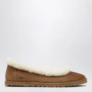UGG 조라 스웨이드 발레 플랫 슈즈입니다. 체스트넛 컬러로, 10mm 양털 및 램스킨 인솔이 적용되어 포근합니다. 가벼운 사탕수수 EVA 아웃솔을 사용했으며, 열 압착된 UGG 로고와 인솔의 직조 로고 라벨이 특징입니다. 이미지