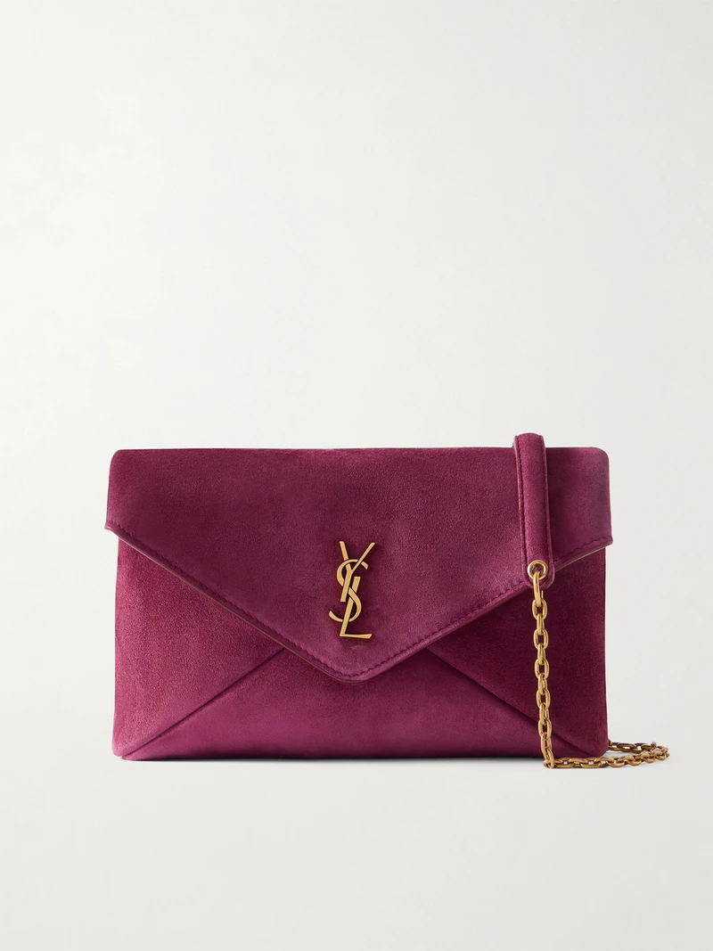 생 로랑의 '카산드라' 라인은 유명한 'YSL' 로고를 디자인한 그래픽 디자이너의 이름을 따서 명명되었습니다. 이탈리아에서 부드러운 스웨이드 소재로 제작된 이 숄더백은 유행을 타지 않는 엔벨로프 형태와 탈부착 가능한 골드톤 체인 스트랩이 특징입니다. 컴팩트한 내부 공간은 카드홀더, 립스틱, 휴대폰과 같은 필수품을 수납하기에 충분합니다. 이미지1
